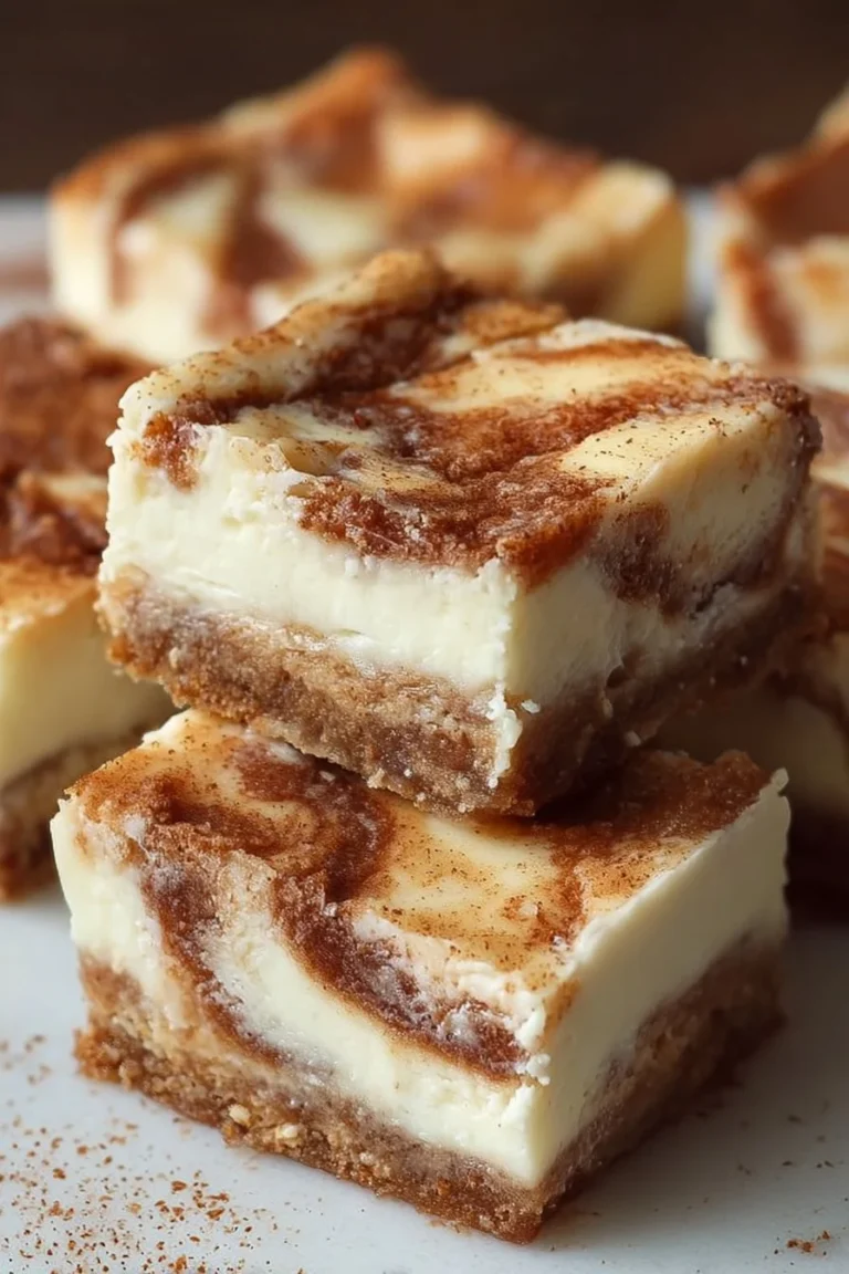 Blender Cinnamon Roll Cheesecake Bars topped with cinnamon and cream cheese frosting.