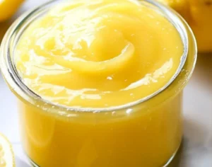 Bowl of homemade easy lemon curd with a slice of lemon.