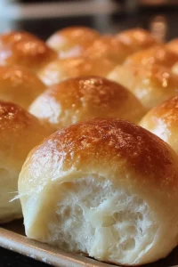 Freshly baked soft and buttery homemade rolls on a wooden table