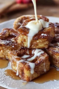 Cinnamon roll French toast bites served with maple syrup and a sprinkle of powdered sugar.